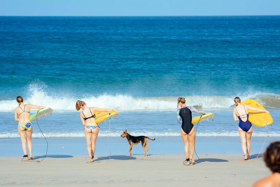 Rapture Surfcamp Playa Avellanas Costa Rica surfen lernen in Boardshorts und Bikini