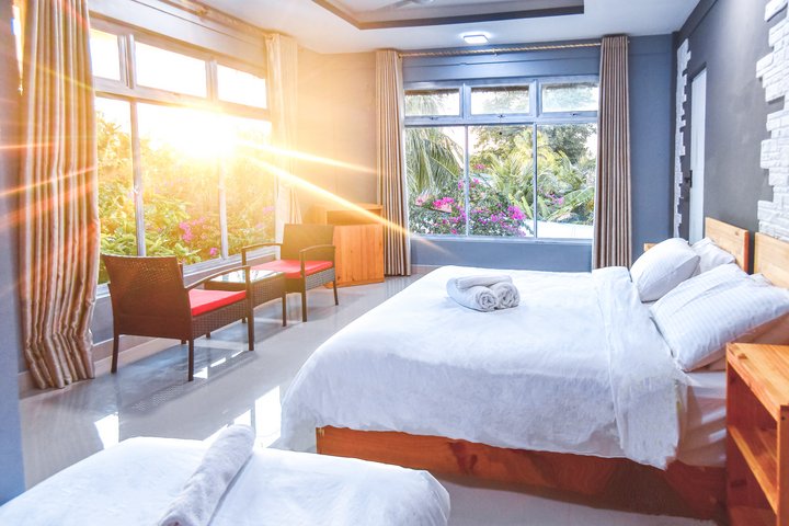 Das große Doppelzimmer ist umgeben vom Palmen Garten