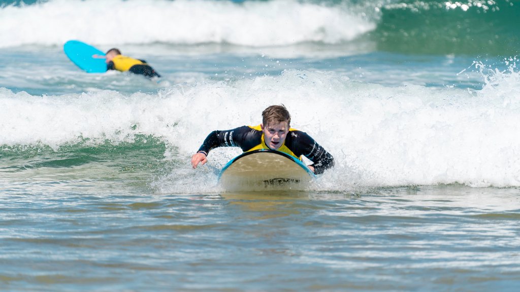 Ein Junge paddelt auf seinem Surfbrett durchs Weisswasser