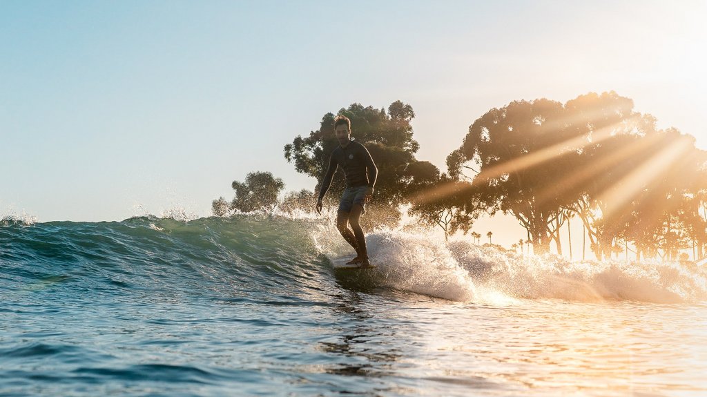 Ein Surfer gleitet entspannt über eine Welle