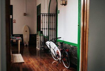 Flur des Hostels mit Fahrrad, Surfboards und schöner Holzausstattung