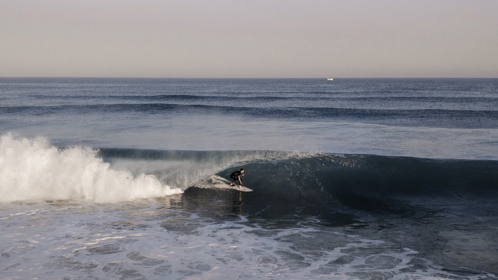Ein Surfer fährt durch eine hohle Welle hindurch