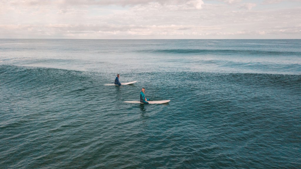 Zwei Surferinnen warten im Line-up auf die perfekte Welle