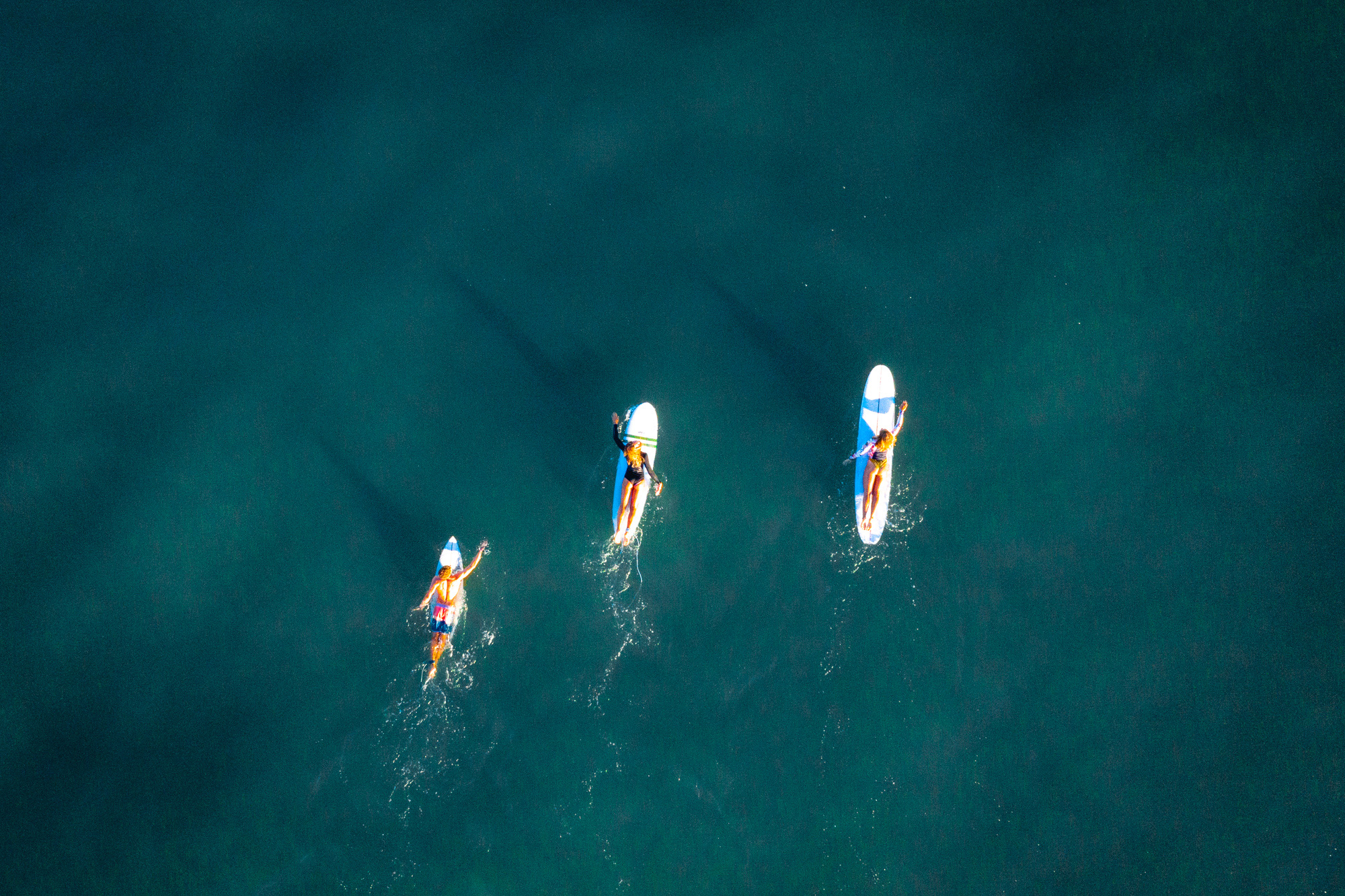Wellenreiten: Drohnenfoto von der Atlantikküste mit drei Longboardern