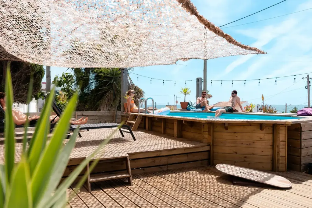 Zusammen sitzen am Pool vom Beachfront Surfcamp Caparica